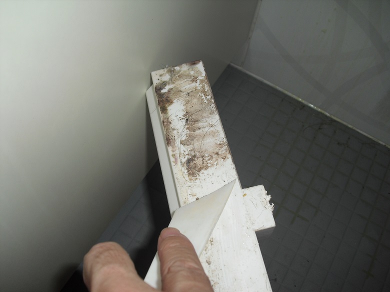 プラスチック製のコテで汚れを剥がしている写真